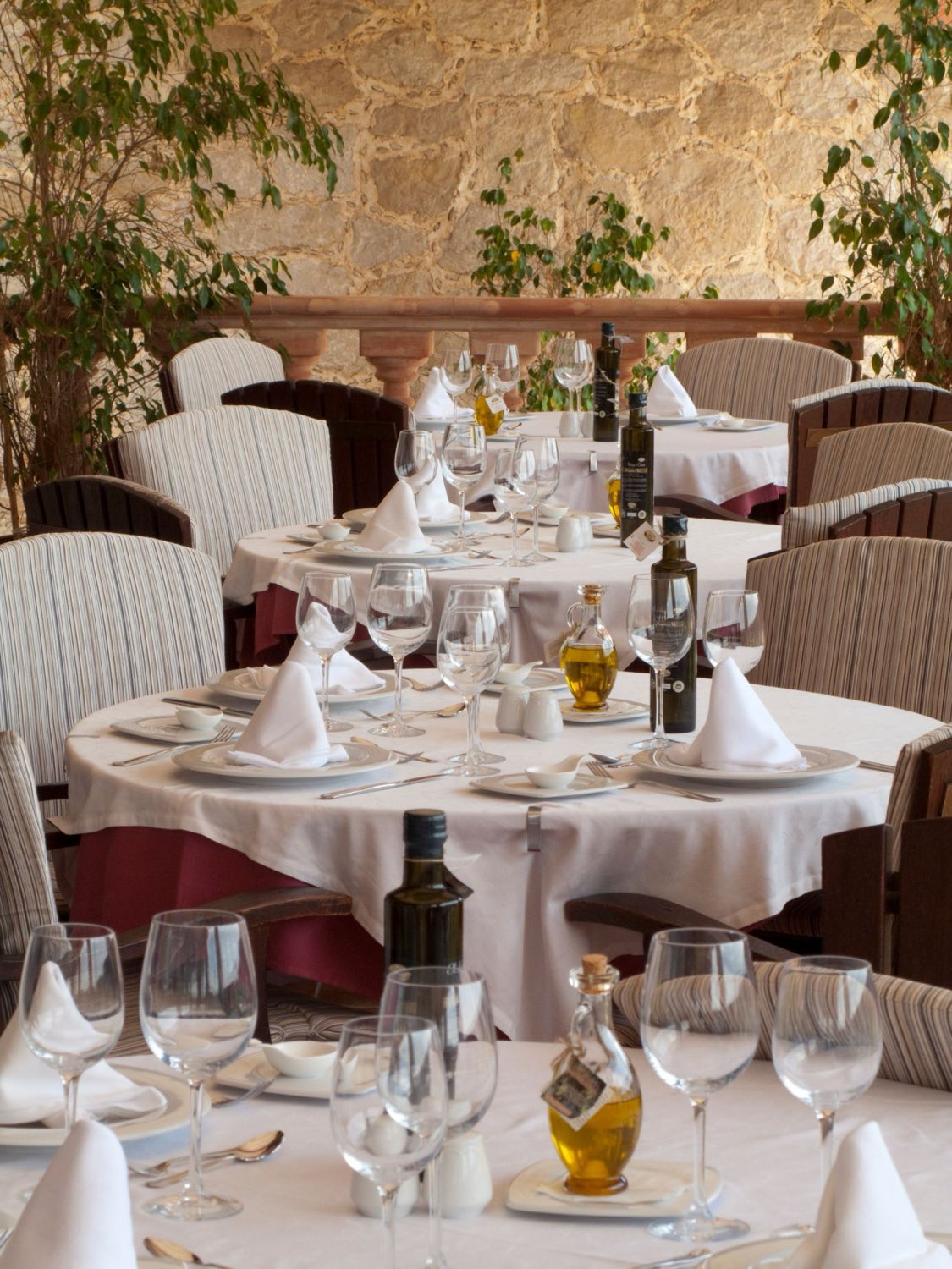 A dining room with laid tables in daylight.