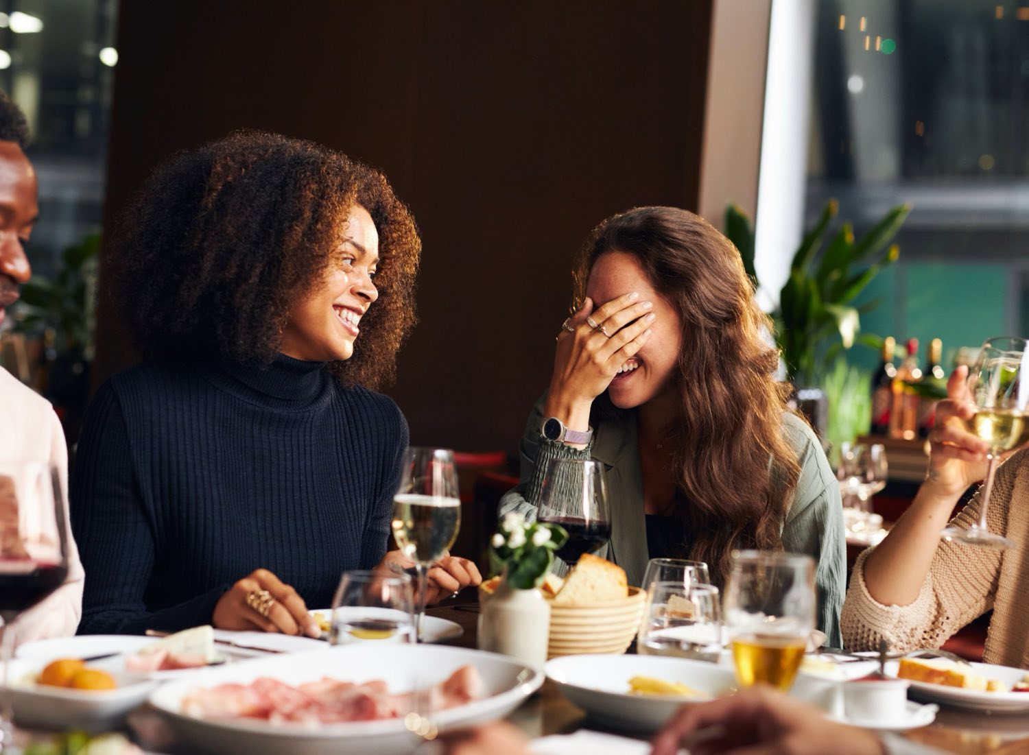 Guests laughing together over dinner.